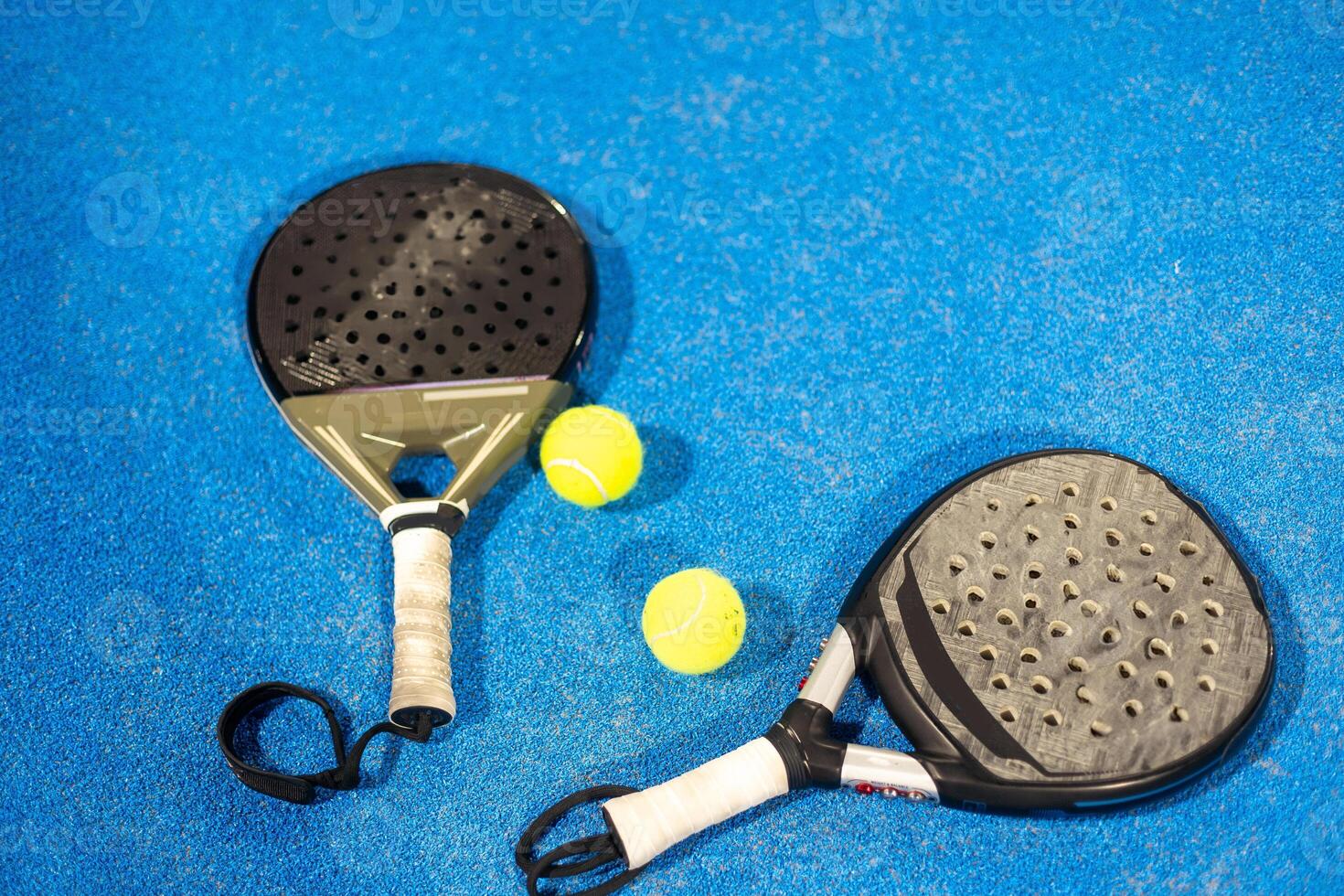 rackets paddle with two balls on blue background photo