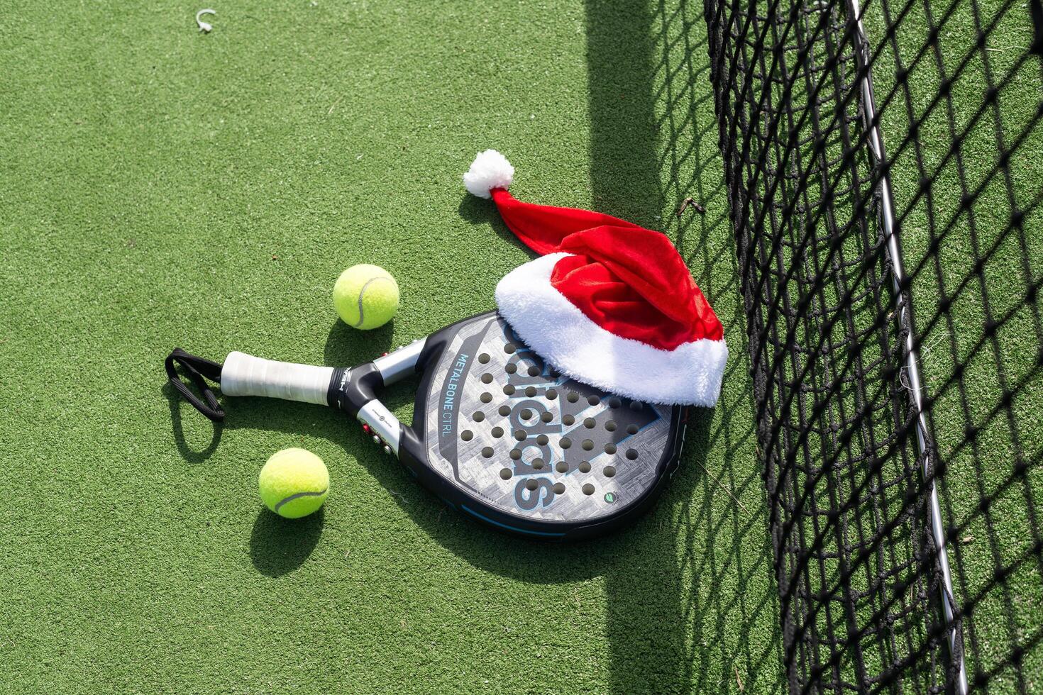 Ukraine Kyiv, April 02 2024. Christmas Open Padel Tournament. Poster for social networks for New Year's games. Padel tennis racket on tournament. paddle racket on court photo