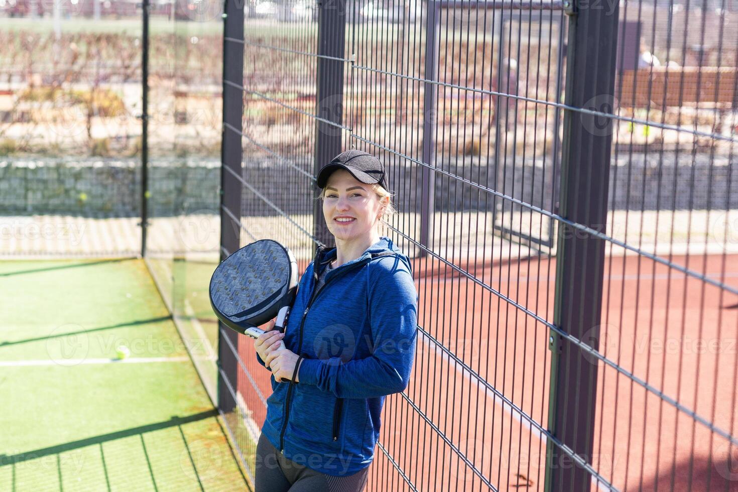 Determined sporty young woman playing padel in court photo