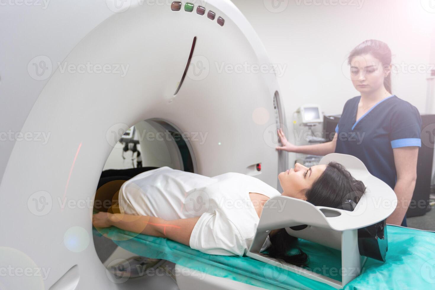 A woman lies on the tomograph table. woman is undergoing computed axial tomography examination in a modern hospital photo