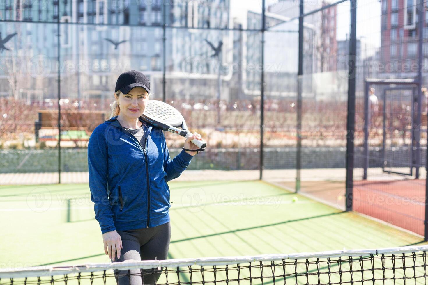 Determined sporty young woman playing padel in court photo