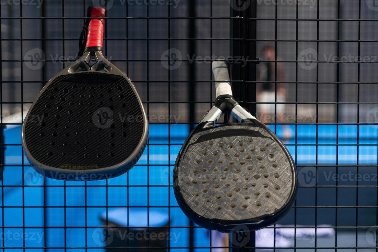 Paddle tennis. Padel racket and ball in front of an outdoor court. photo