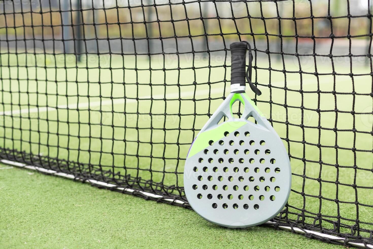 Paddle racket, next to the ball and on a carpet of the play area photo