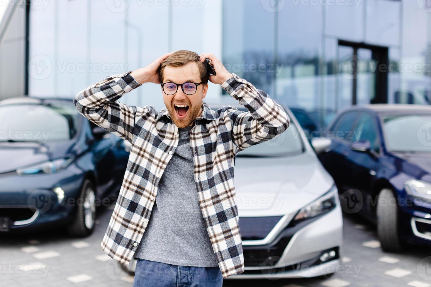 A young man is very impressive and happy, standing in front of his new car photo