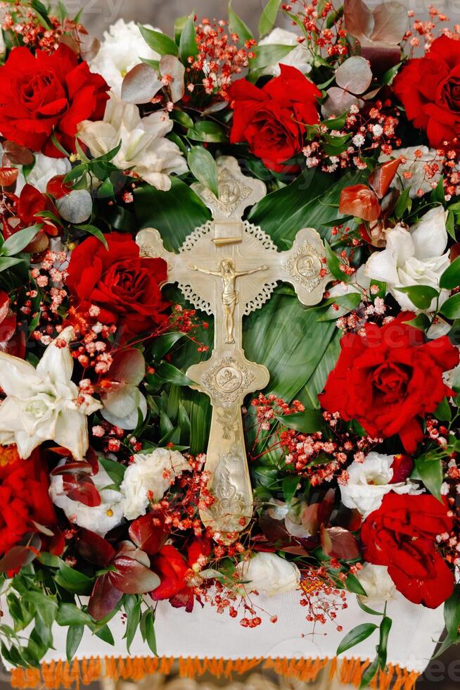 Cross surrounded by red and white flowers photo