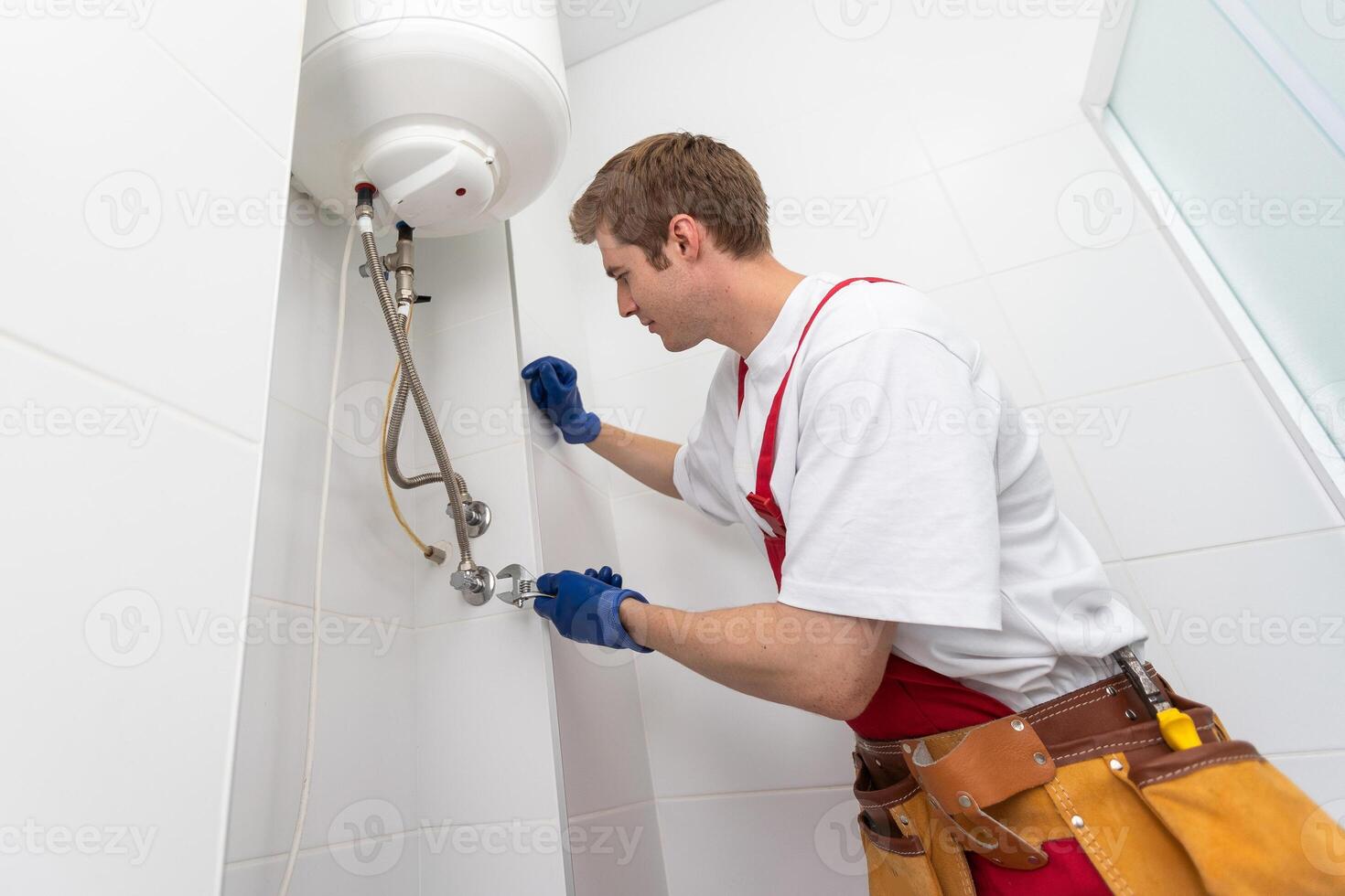 Professional plumber checking a boiler and pipes, boiler service concept. photo