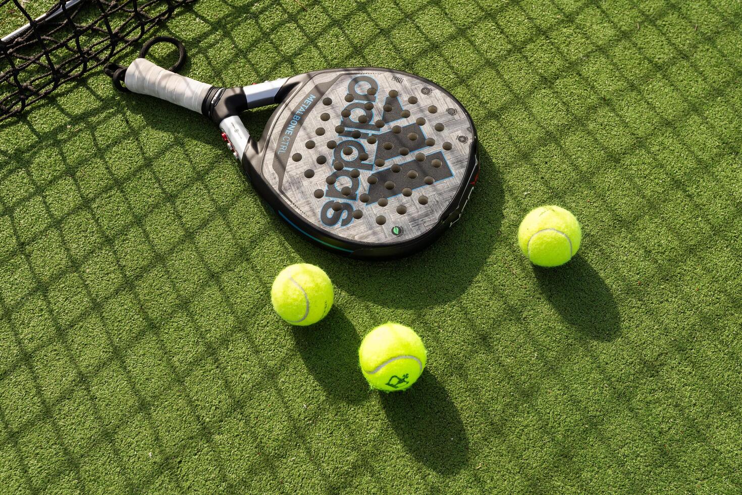 Ukraine Kyiv, 31.03.2024. Padel racket adidas and padel ball on a green court photo