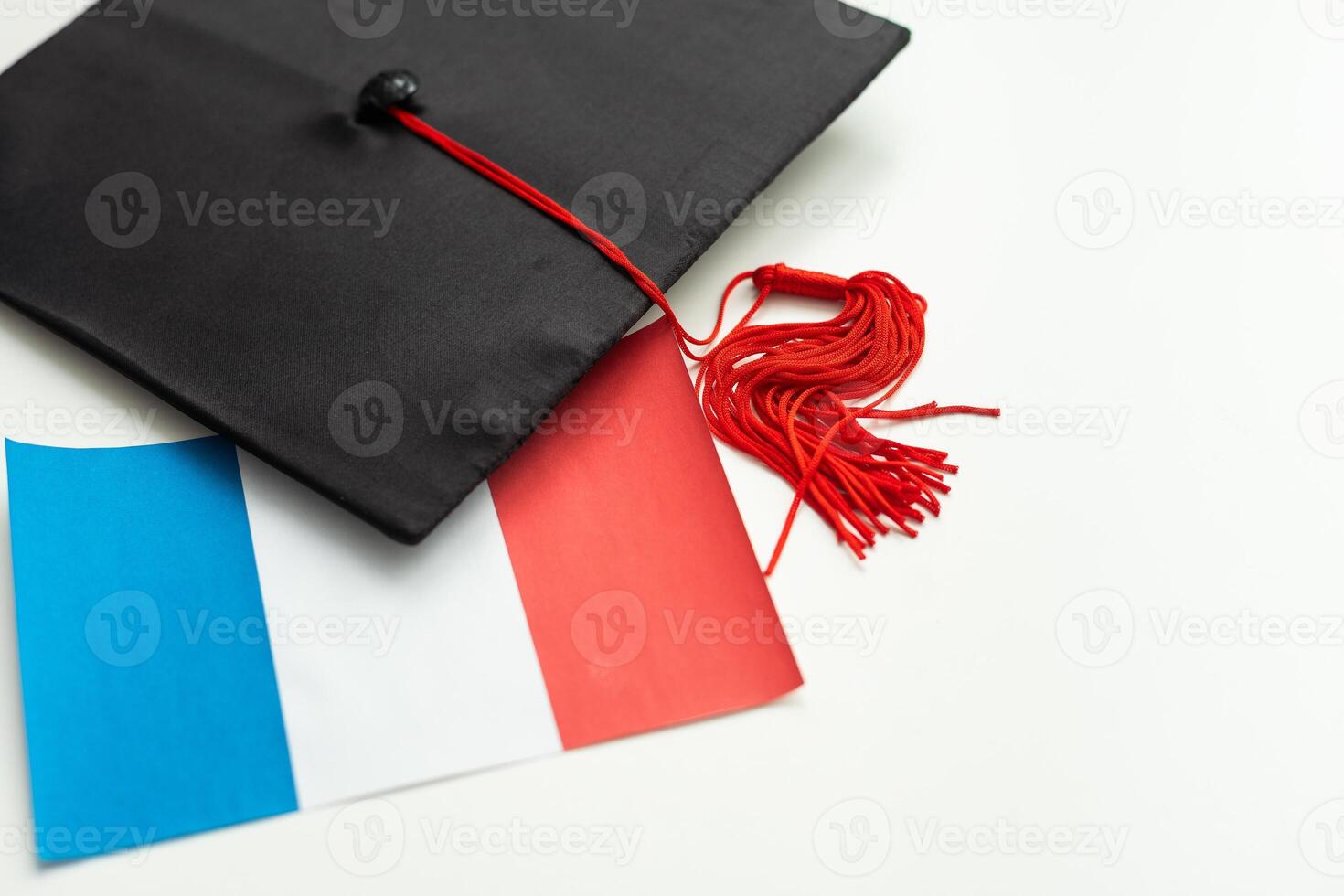 Graduation cap with red tassel isolated on white background photo