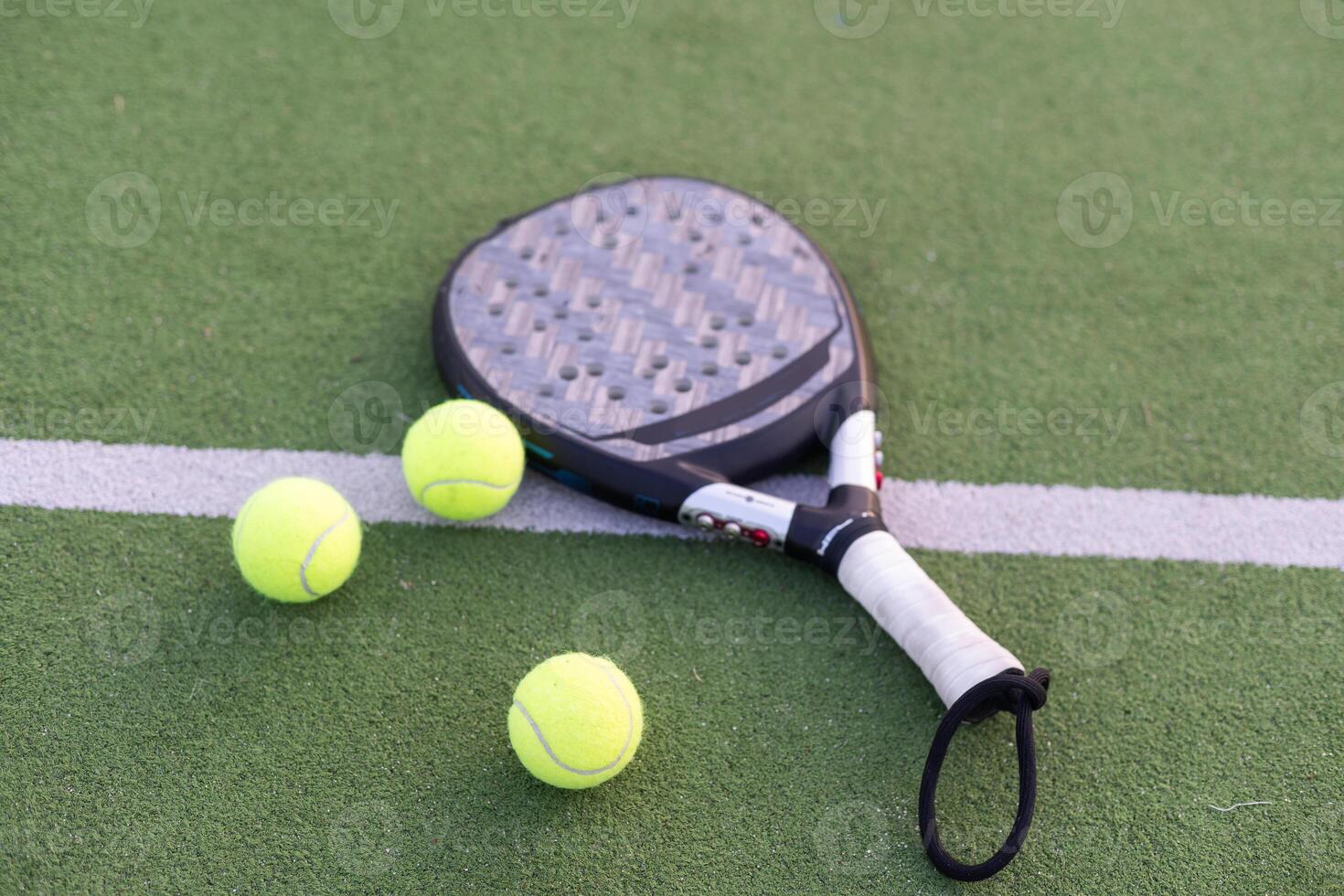 Paddle tennis racket, ball and net on the grass photo