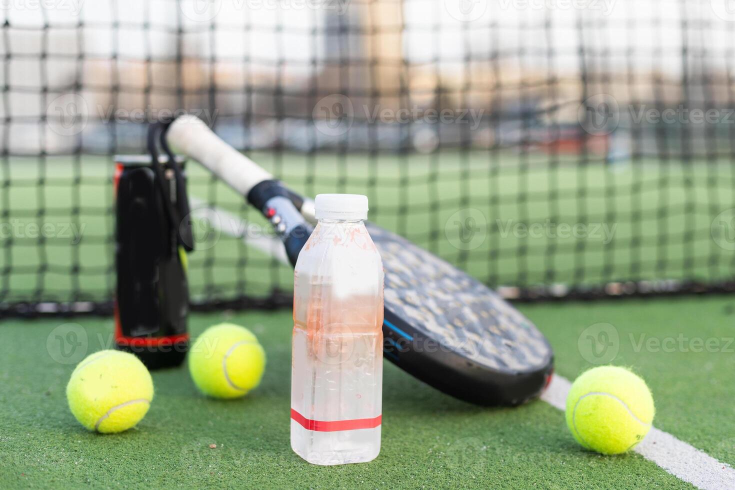 Paddle tennis racket, ball and net on the grass photo