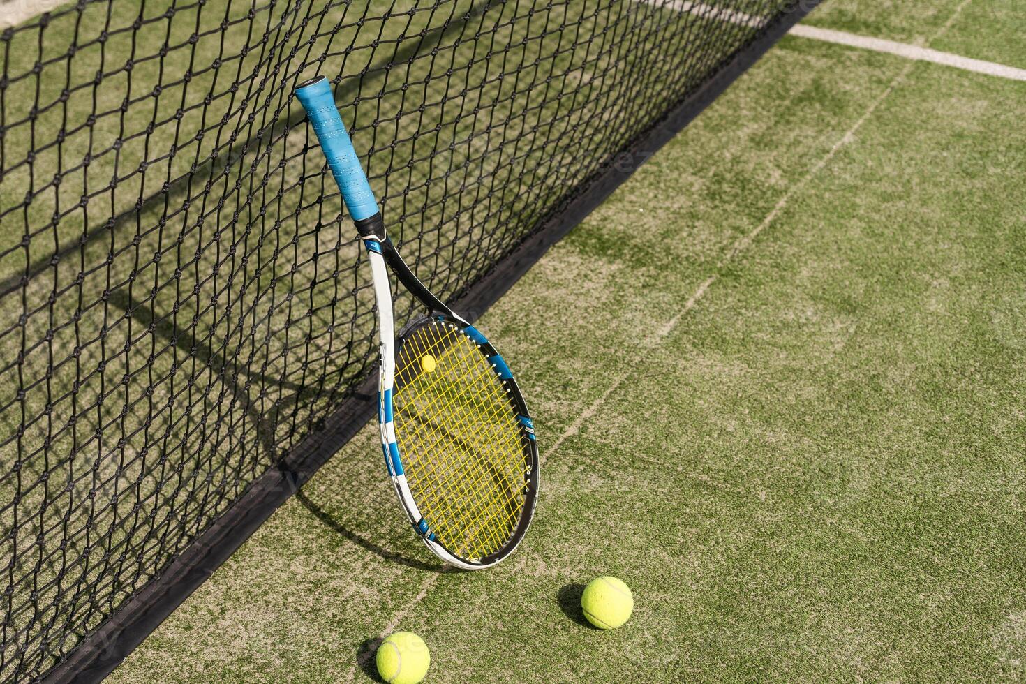 Tennis racket with a set of balls photo