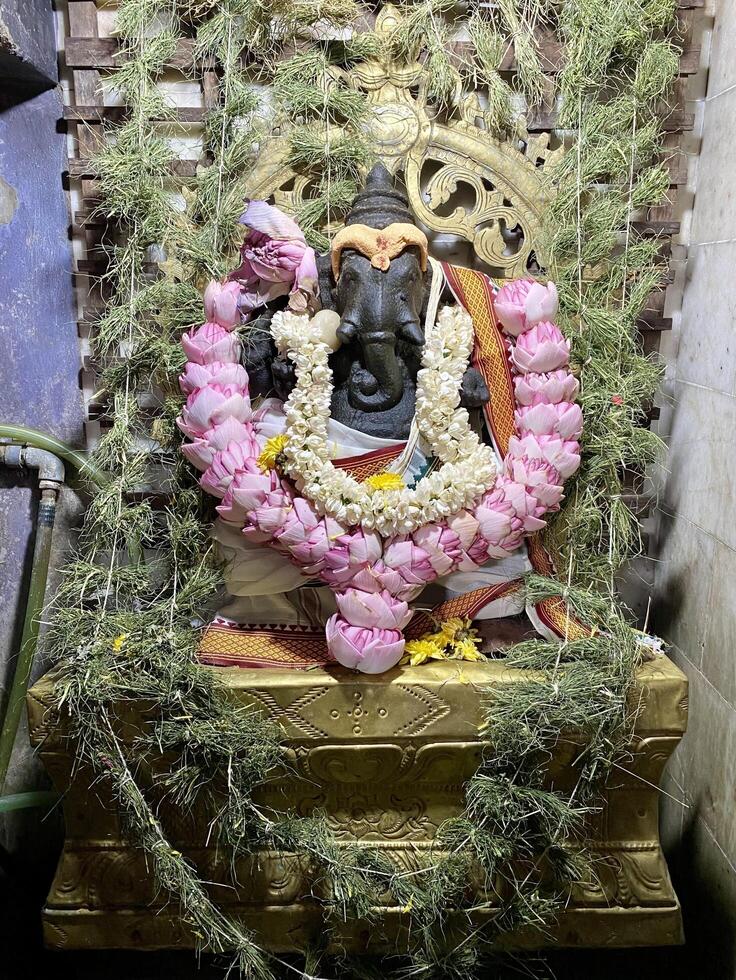 Statue of Hindu Deity Ganesha Decorated with Flowers photo