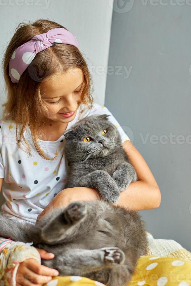 Teen girl with a broken arm orthopedic cast play with cat photo