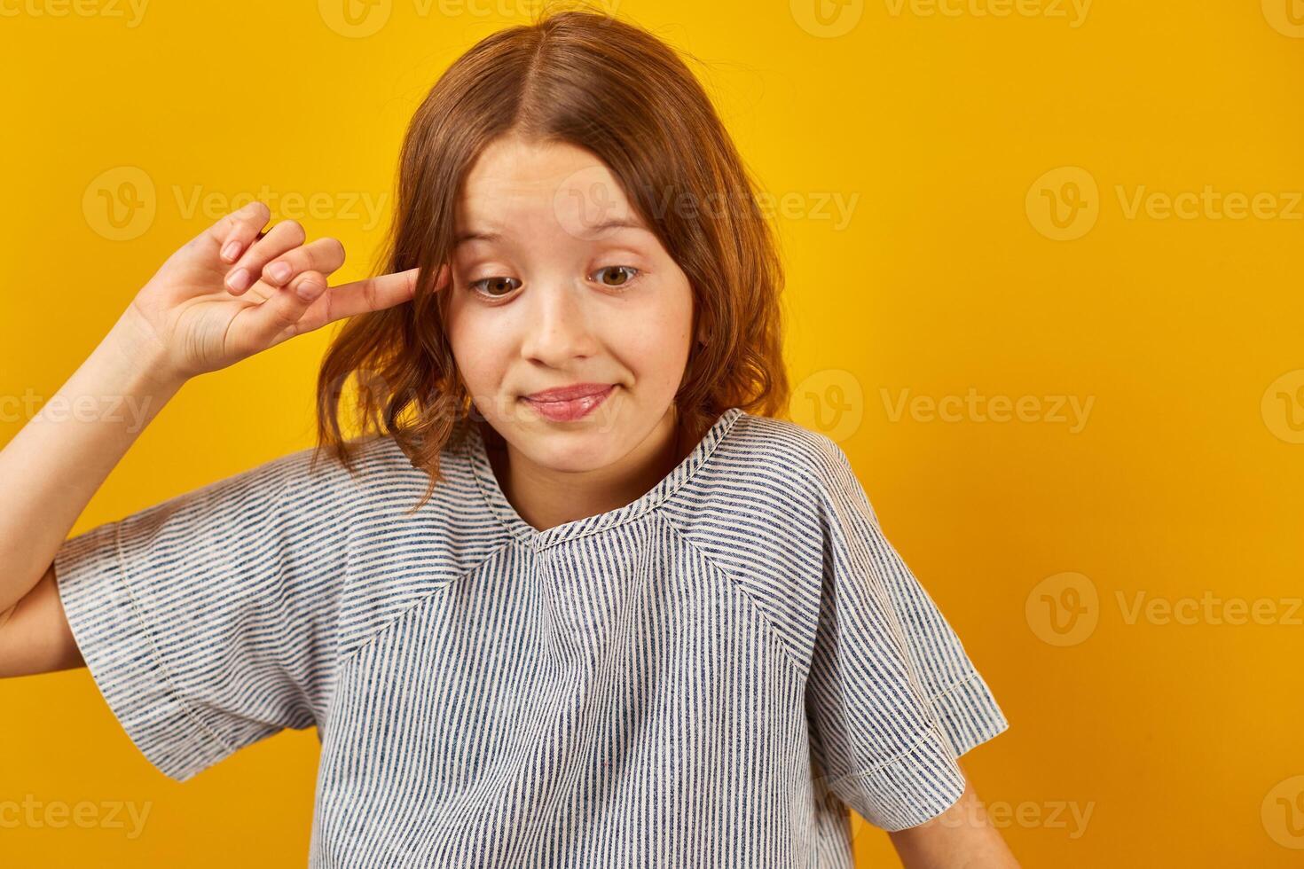 Teen girl portrait twists the finger near the temple photo