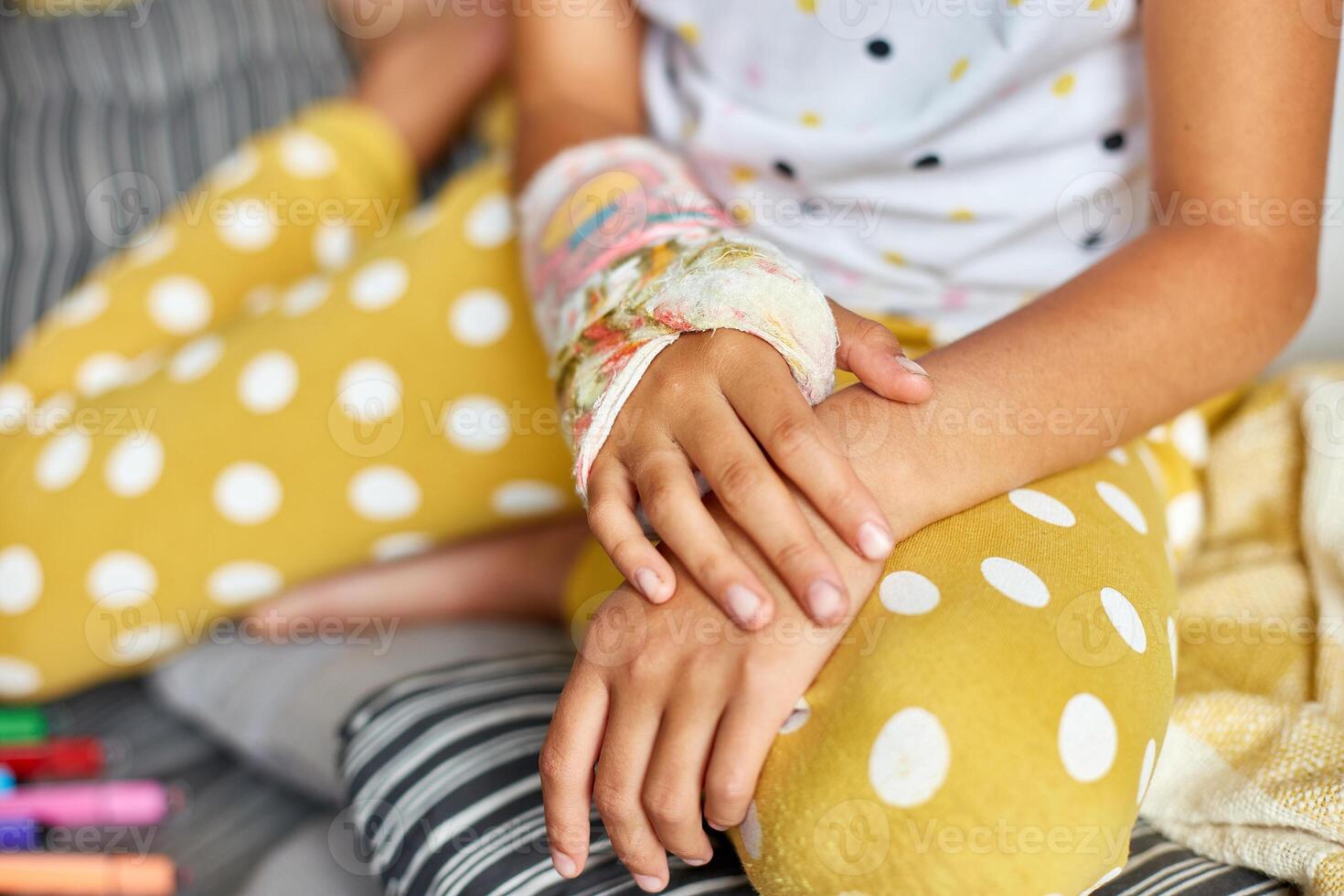Teen girl with a broken arm at home an orthopedic cast photo