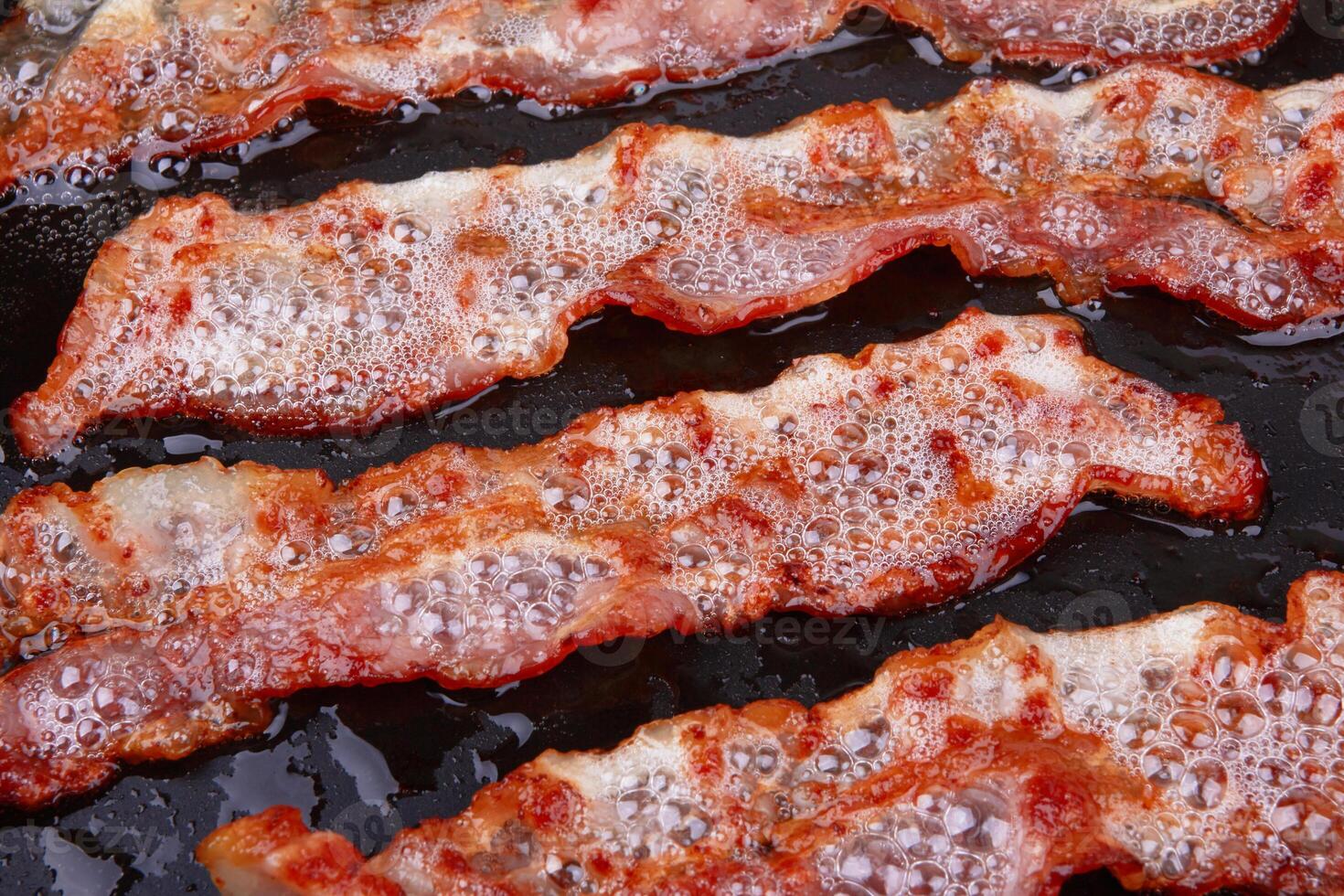 Fried bacon in a frying pan photo