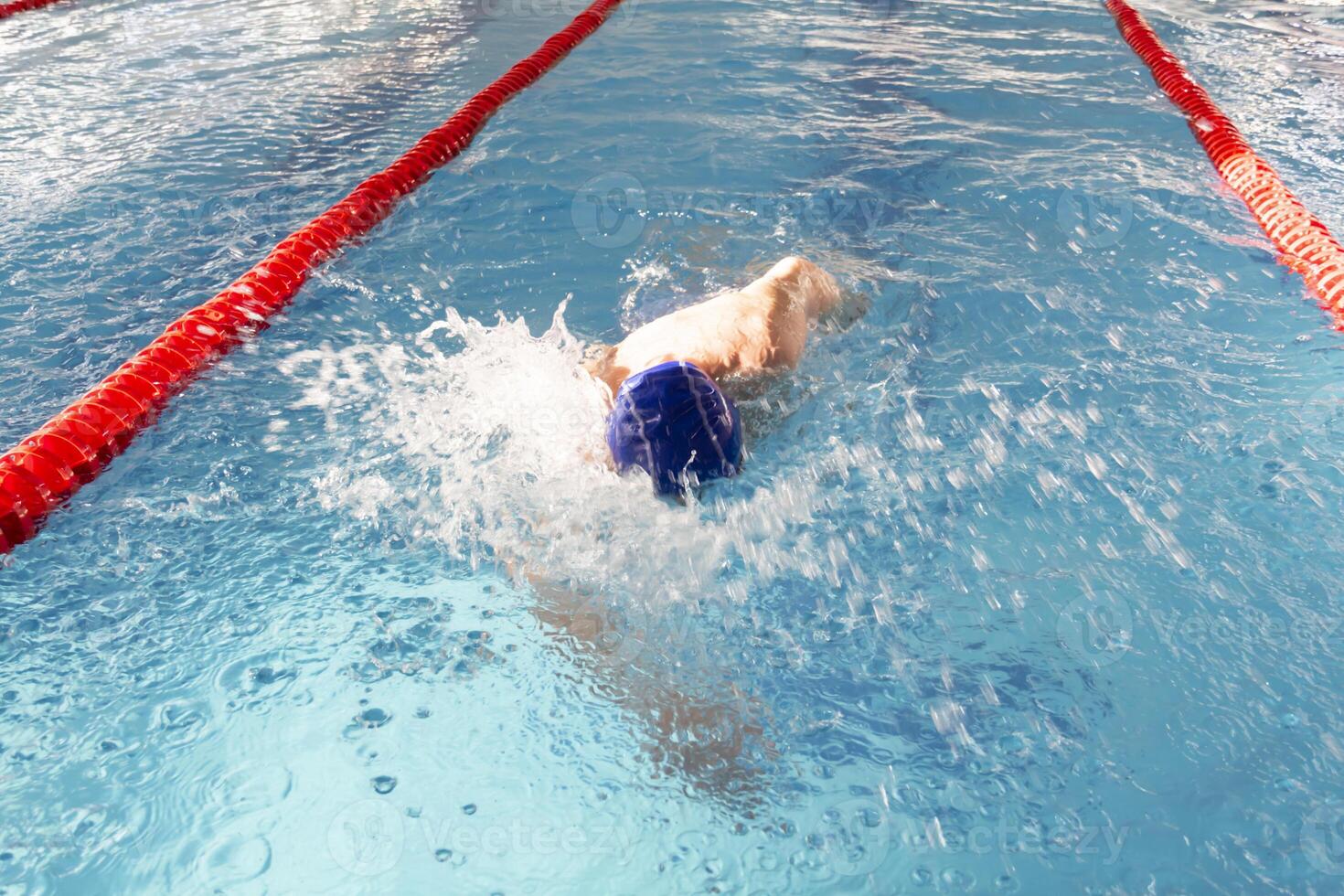 A pensioner of 70 years rests and swims in the pool in a clean, blue pool in the fresh air on vacation. photo