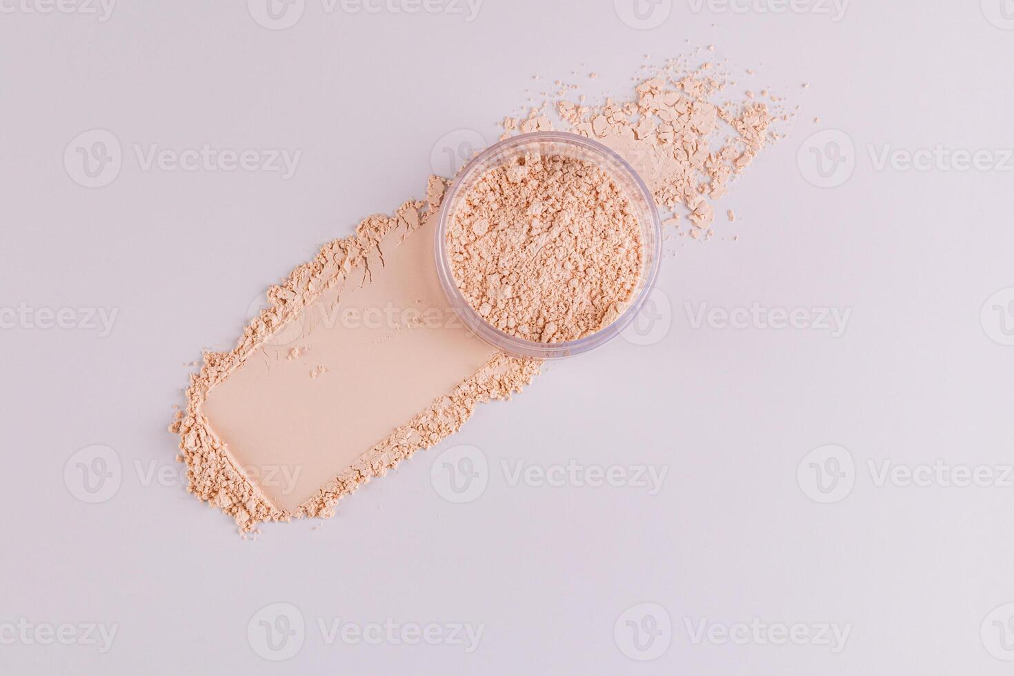 The jar of light loose powder in the jar sits on the powder swatch next to the makeup pad. Top view. Delicate matte powder. Easy blending photo