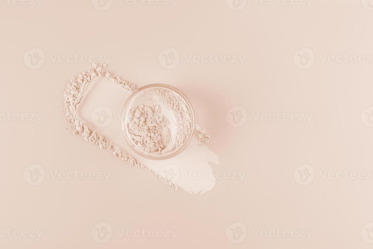 The jar of light loose powder in the jar sits on the powder swatch next to the makeup pad. Top view. Delicate matte powder. Easy blending photo