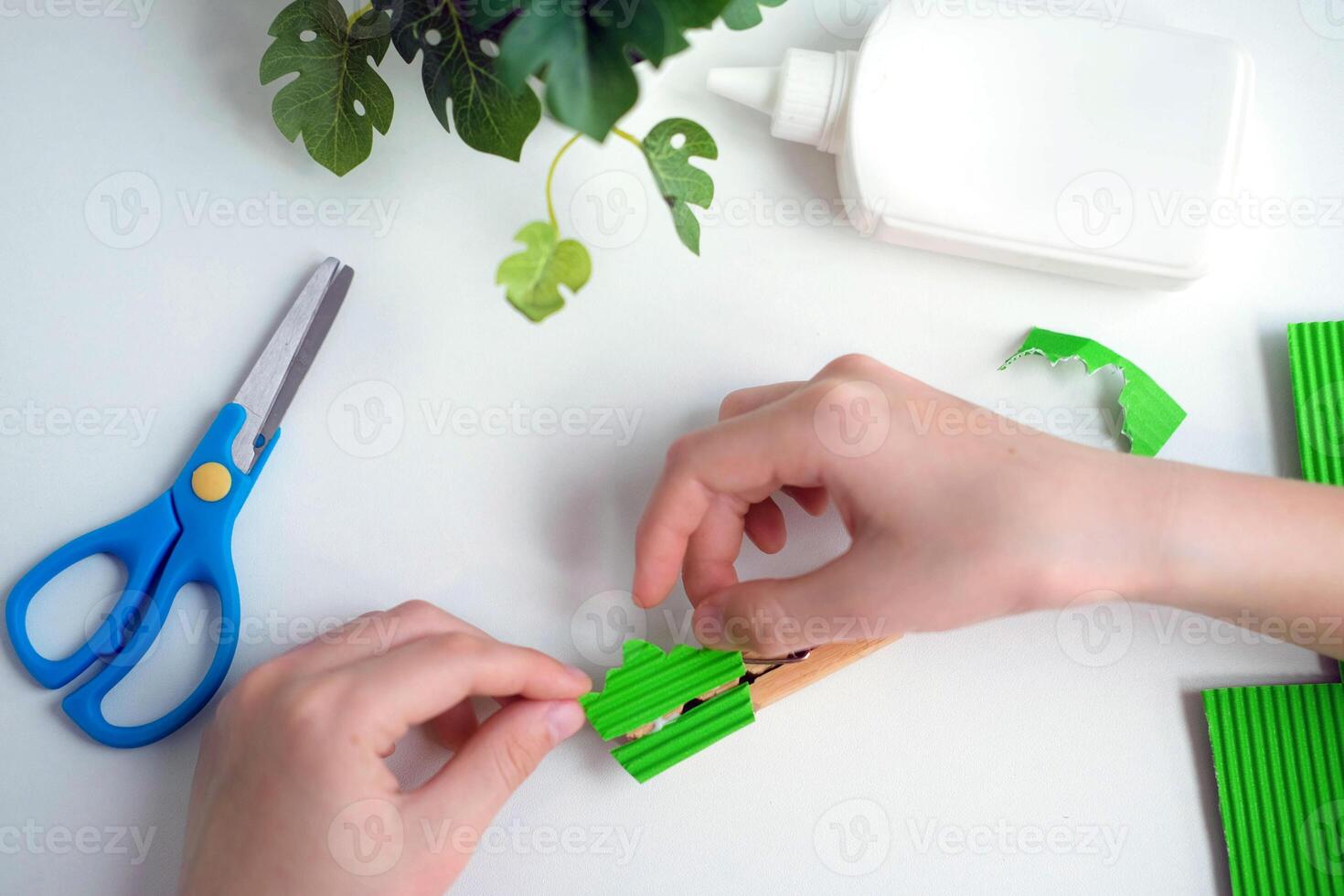 Children's craft made from paper and clothespins. step by step instructions from green paper. DIY concept. Step-by-step photo instructions. Step 10.