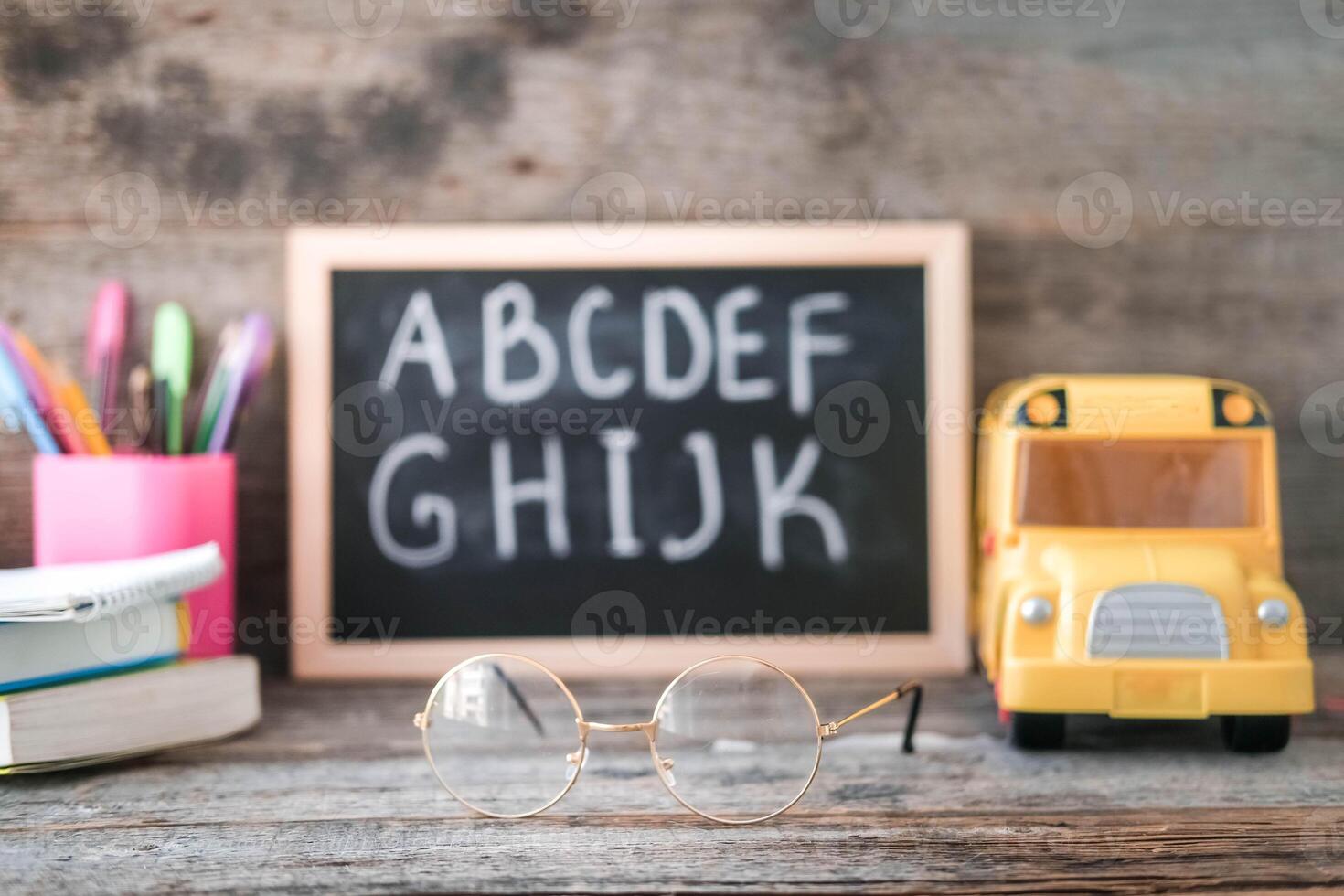 School board on a wooden background. Glasses for vision correction. photo
