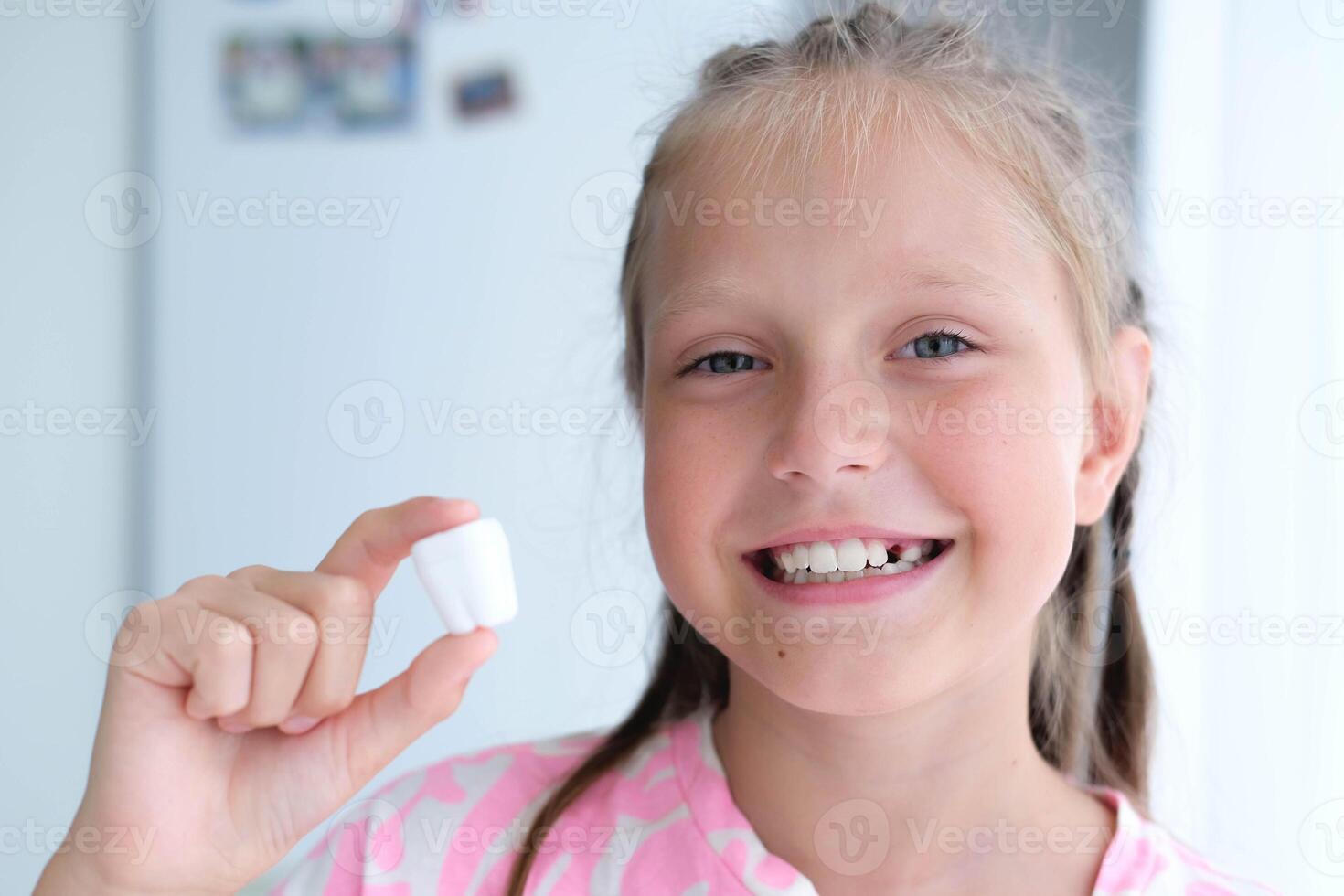 The child holds a plastic milk tooth in his hands. The concept of healthy teeth. photo