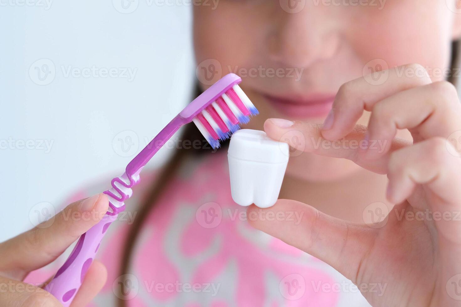 The child holds a plastic milk tooth and a toothbrush in his hands. The concept of brushing and caring for teeth. photo