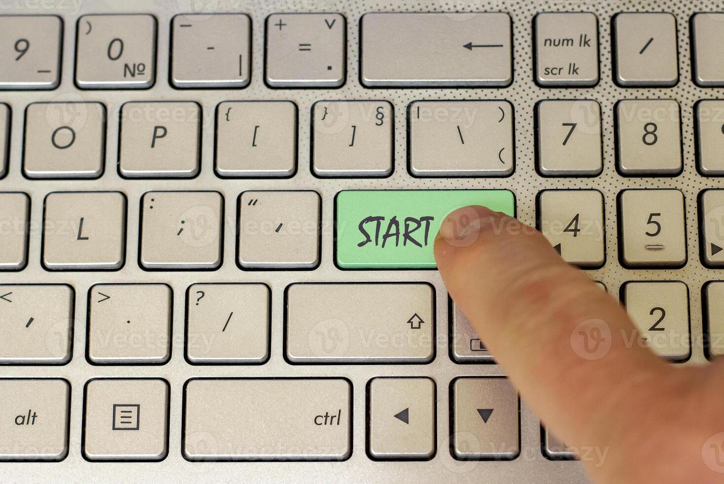 Finger ready to push the keyboard button Start. photo