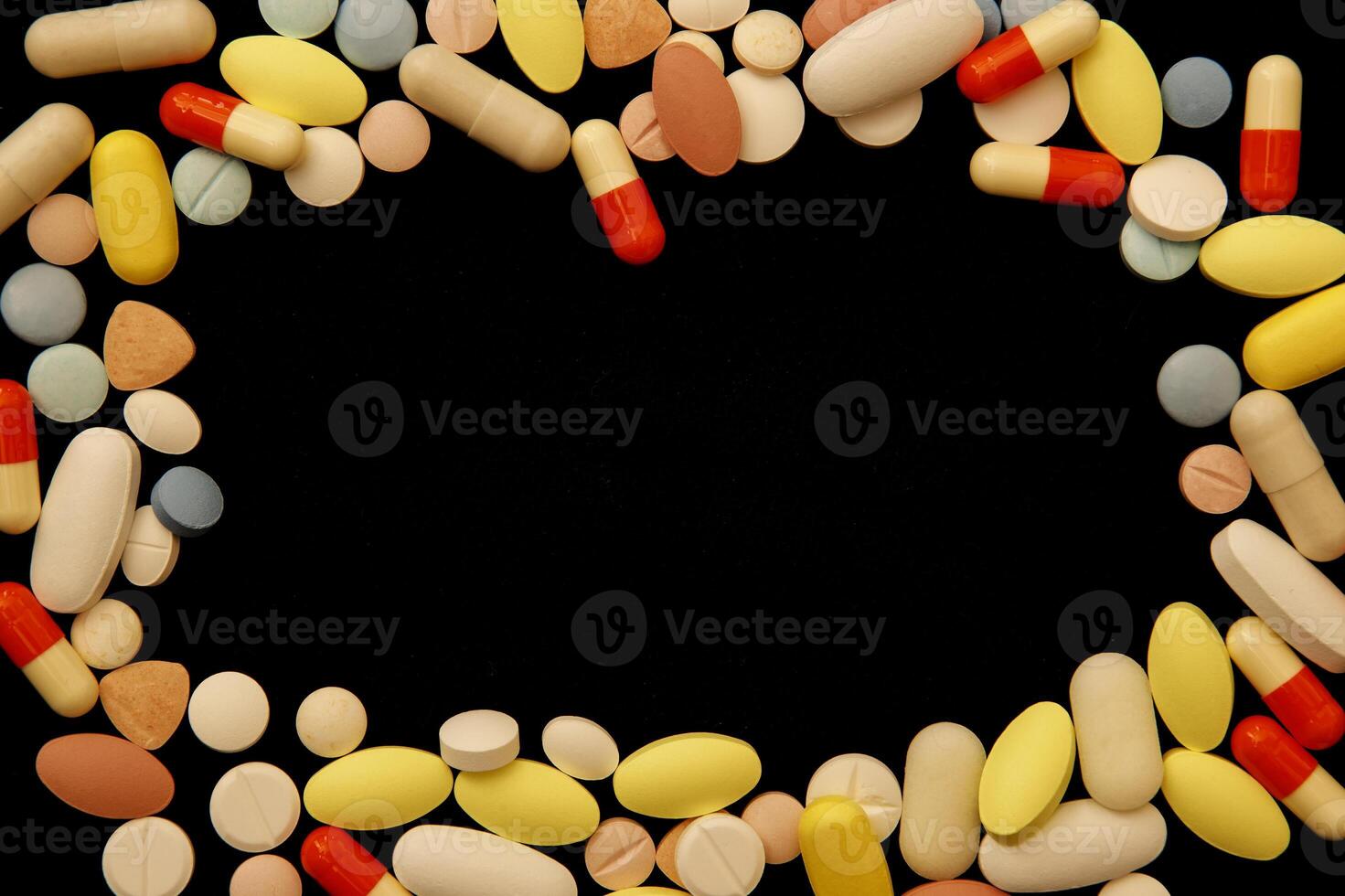 Many different colored drugs and pills around empty space photo