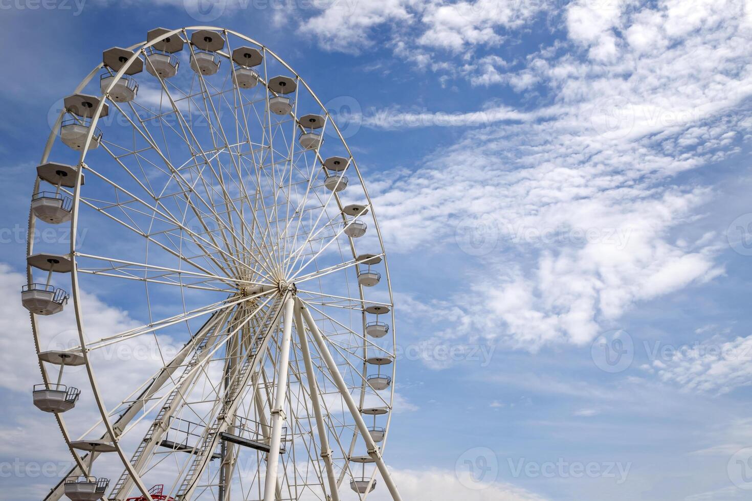 Ferris wheel an amusement park funfairs attraction with a cloudy blue sky photo
