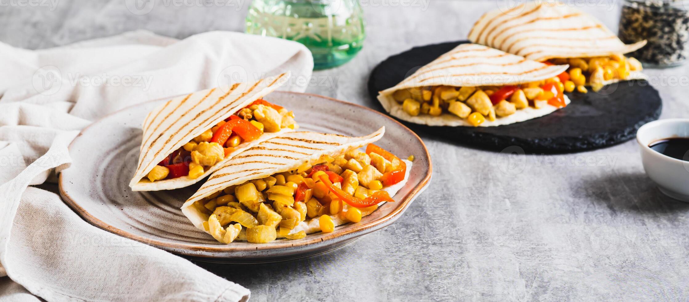 Mexican quesadilla with chicken, corn and bell pepper on a plate on the table web banner photo