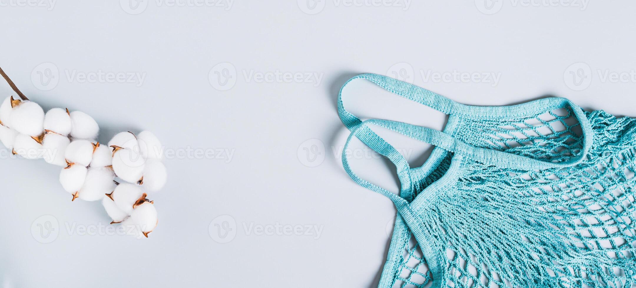 Concept of refusing plastic bags. String bag and cotton branch on a blue background web banner photo
