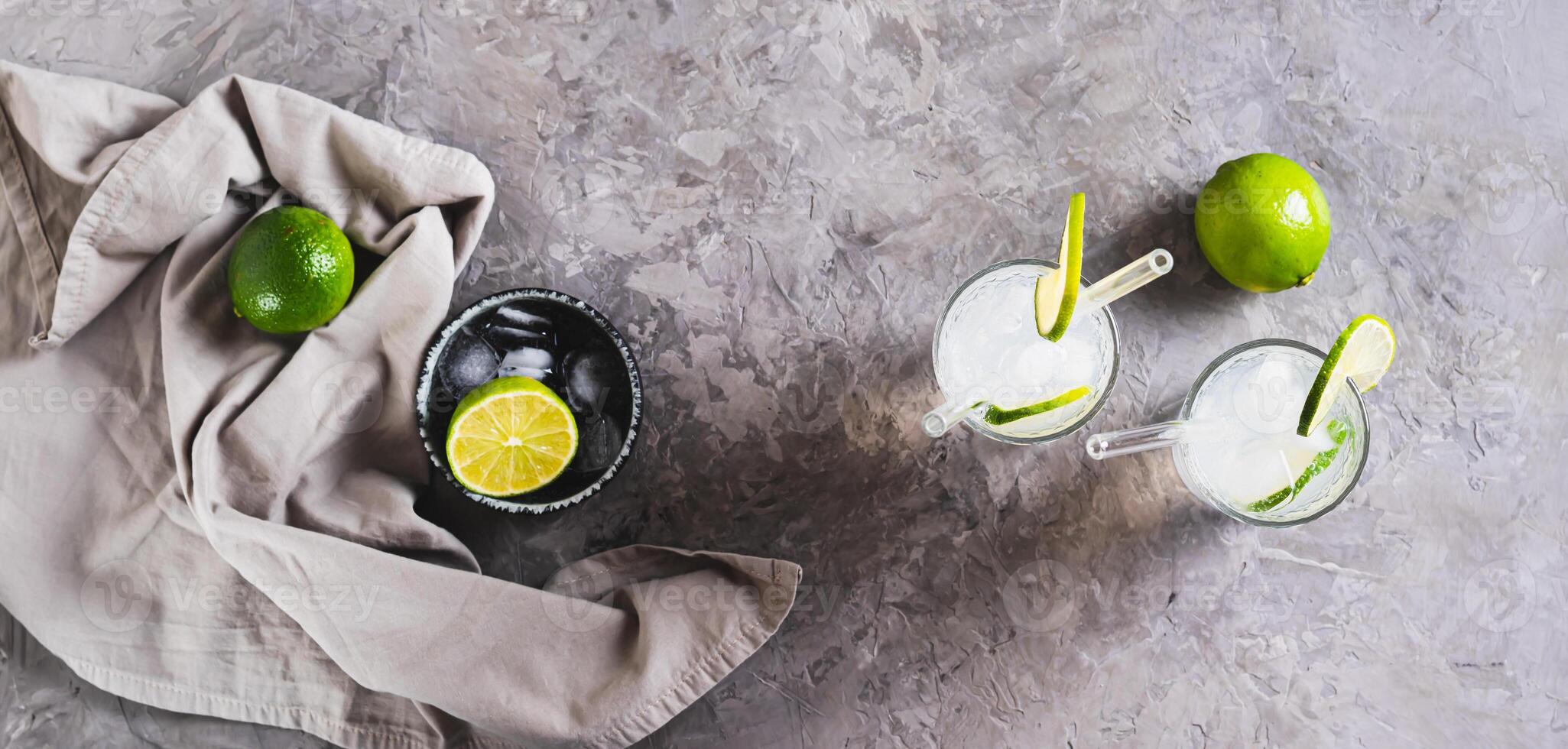 Alcoholic mojito cocktail with lime and ice in glasses on the table top view web banner photo