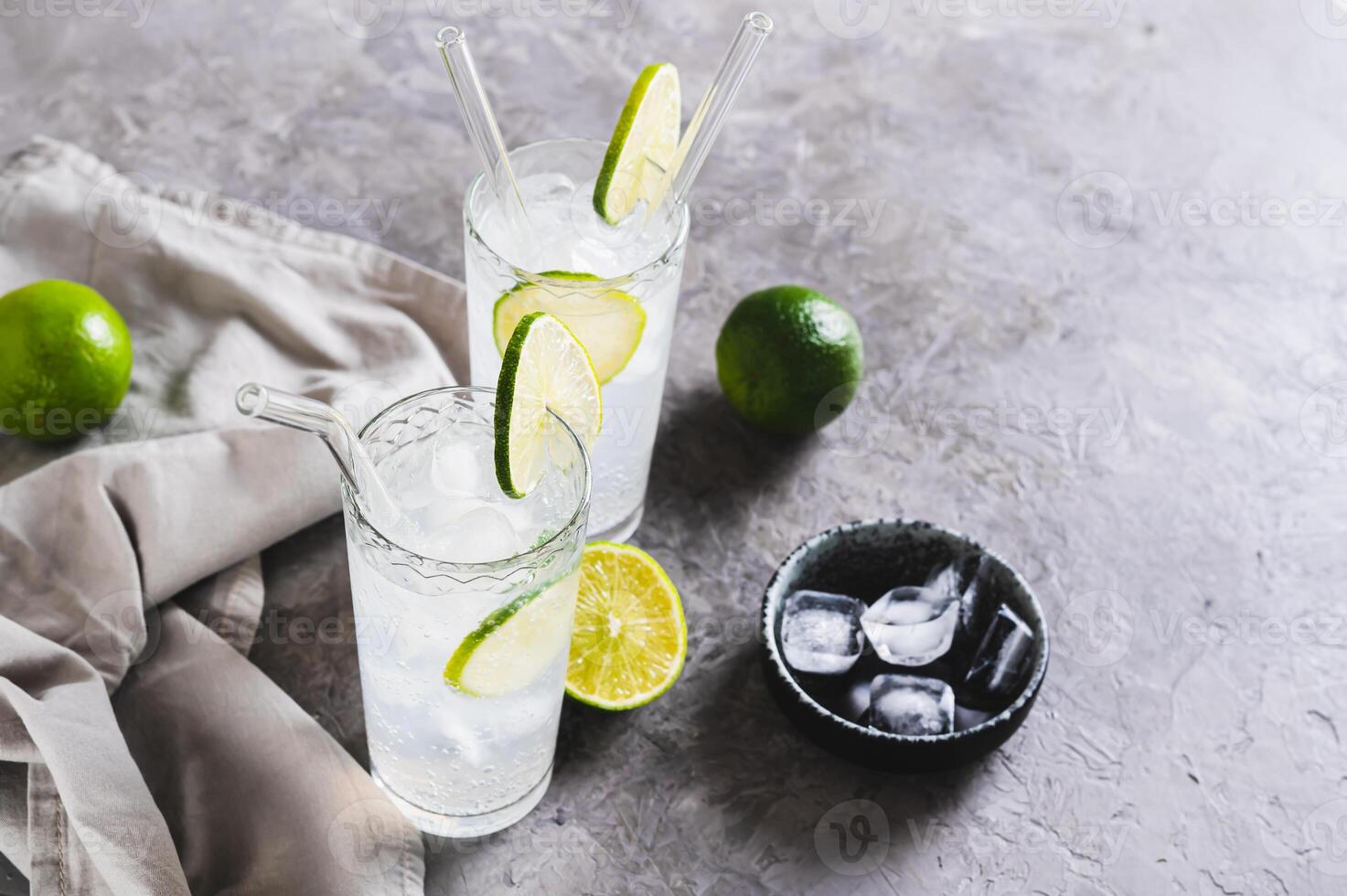 Alcoholic mojito cocktail with lime and ice in glasses on the table photo