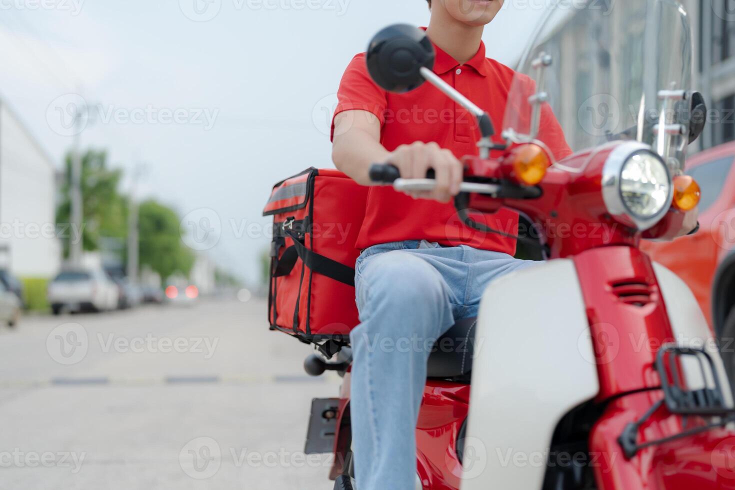 Delivery rider on red motorbike with insulated food box parked outdoors photo