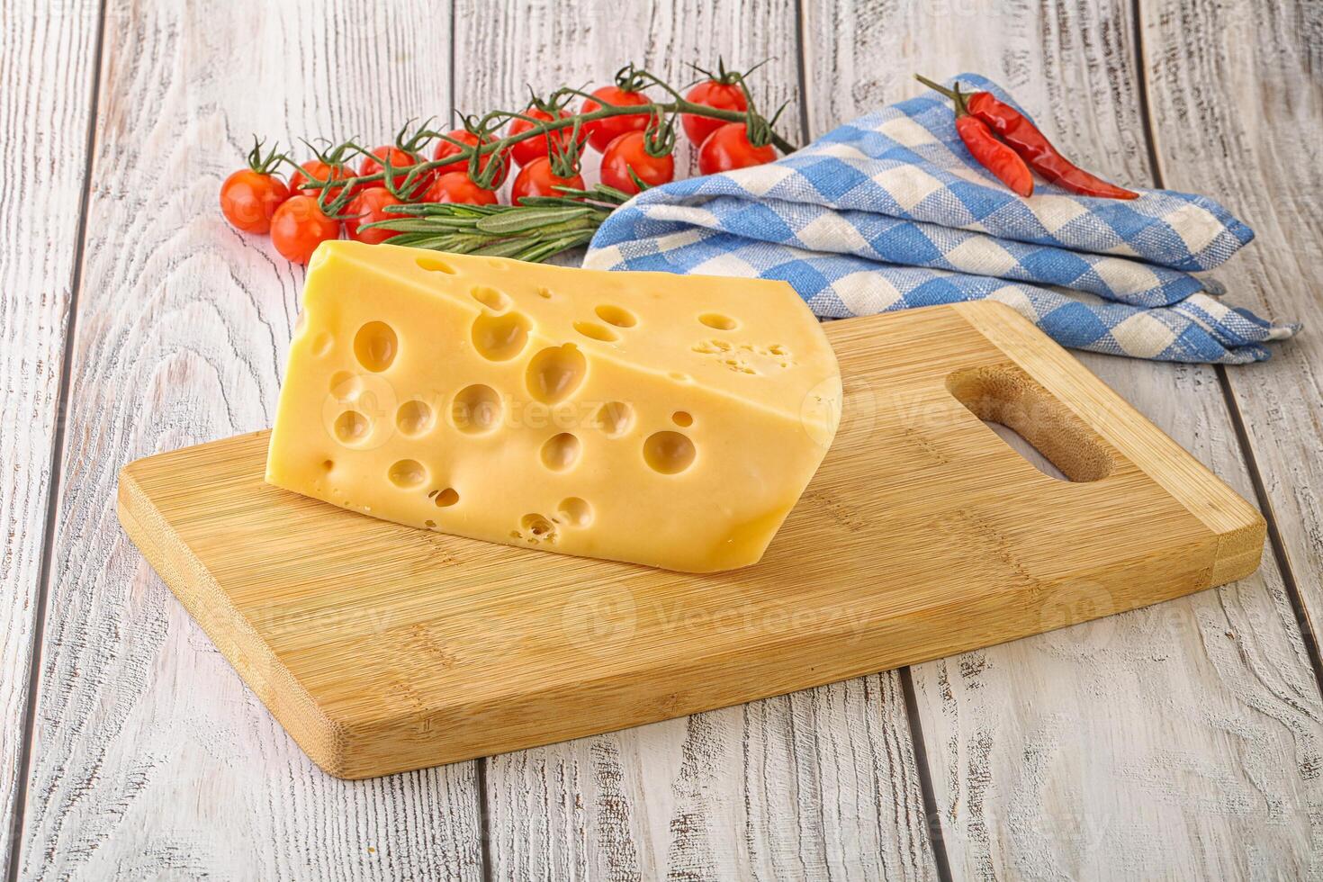 Maasdam cheese piece over board photo