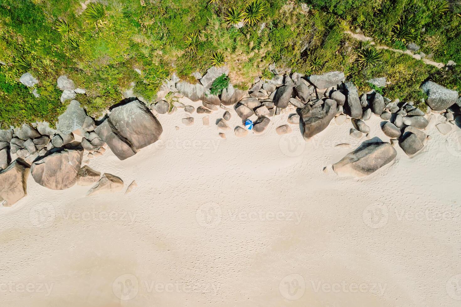 Amazing beach in tropics with umbrella and stones rock. Aerial view. Top view photo
