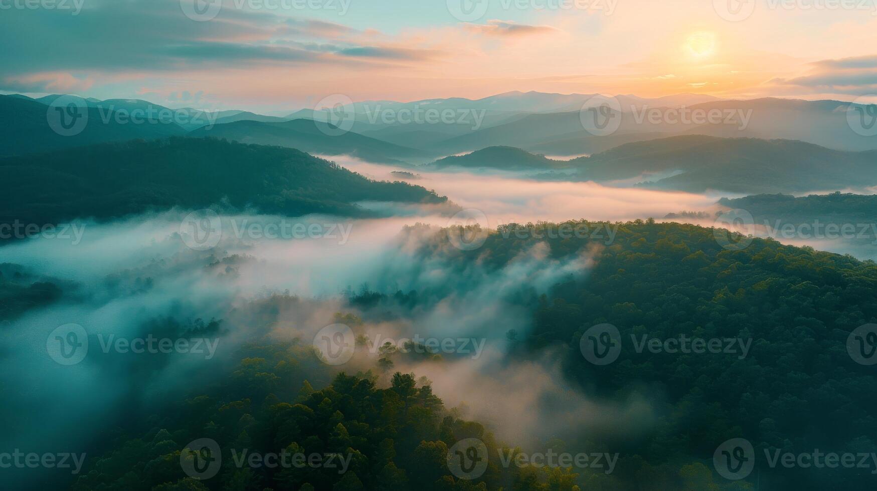 An aerial view of misty mountains at dusk with water, clouds, and dramatic sky photo