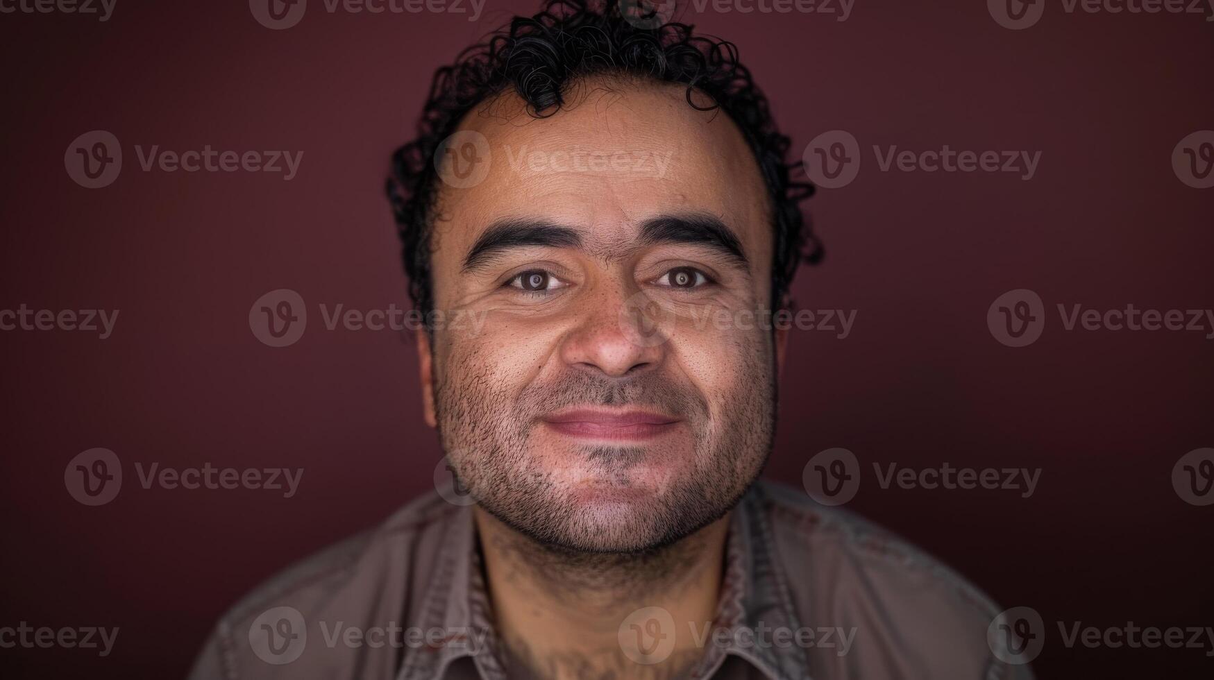 Man with a beard smiling, making eye contact with camera photo