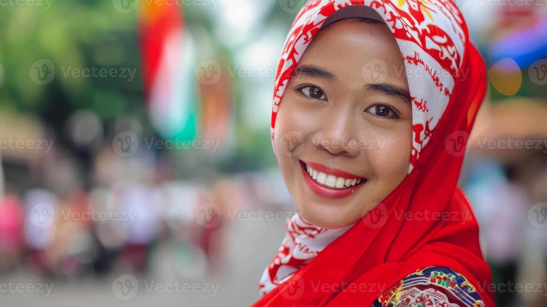 A woman in a red hijab is smiling, showing happiness and joy for the camera photo