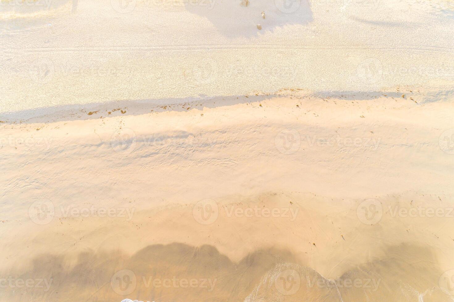 sand on the shore of a beach at sunrise at low tide aerial top view with drone photo