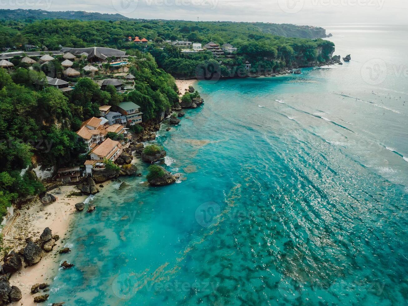 Aerial view of ocean with coastline and plastic pollution in water on Bali photo