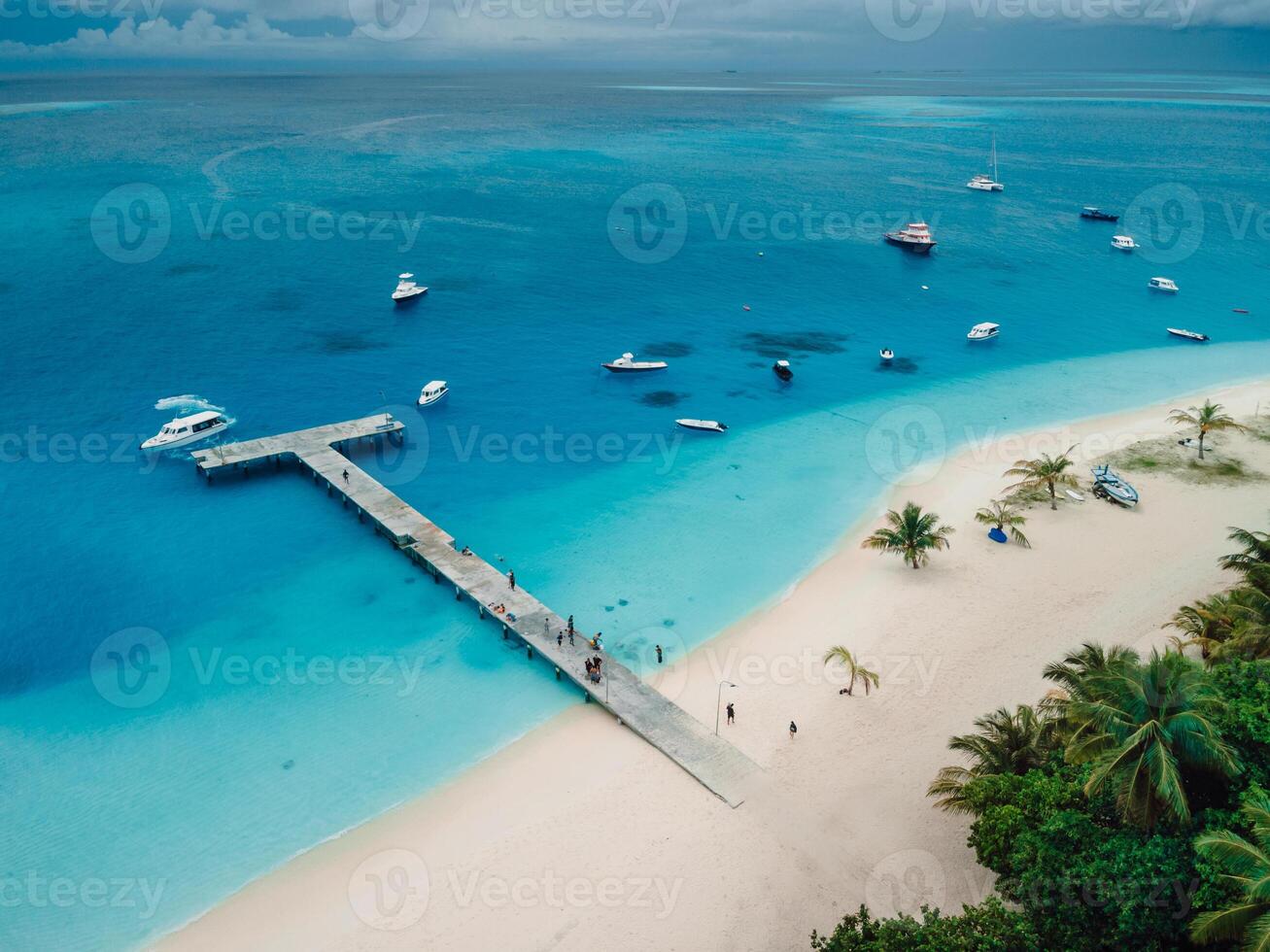 Aerial drone view of paradise Maldives tropical beach with pier and speed boats on island. Summer and travel vacation concept. photo