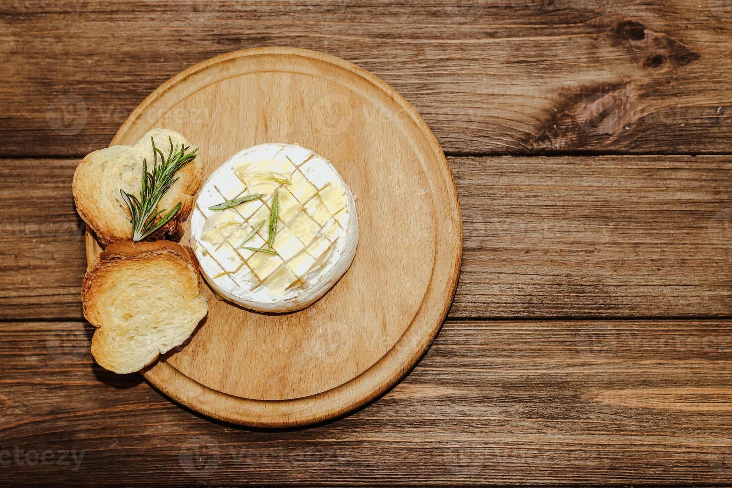 White baguette cut into pieces with olive oil and Camembert cheese on the table. photo