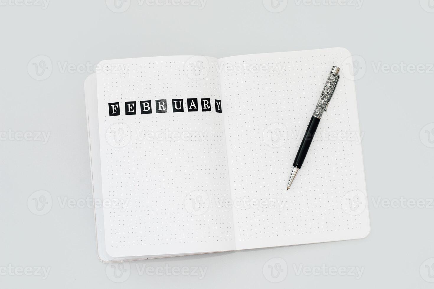 Filling in the diary, the inscription February in the notebook in a dot photo