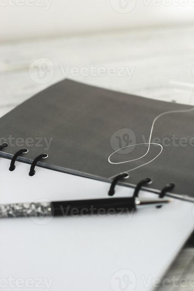 Notepad diary with pen on the desktop photo