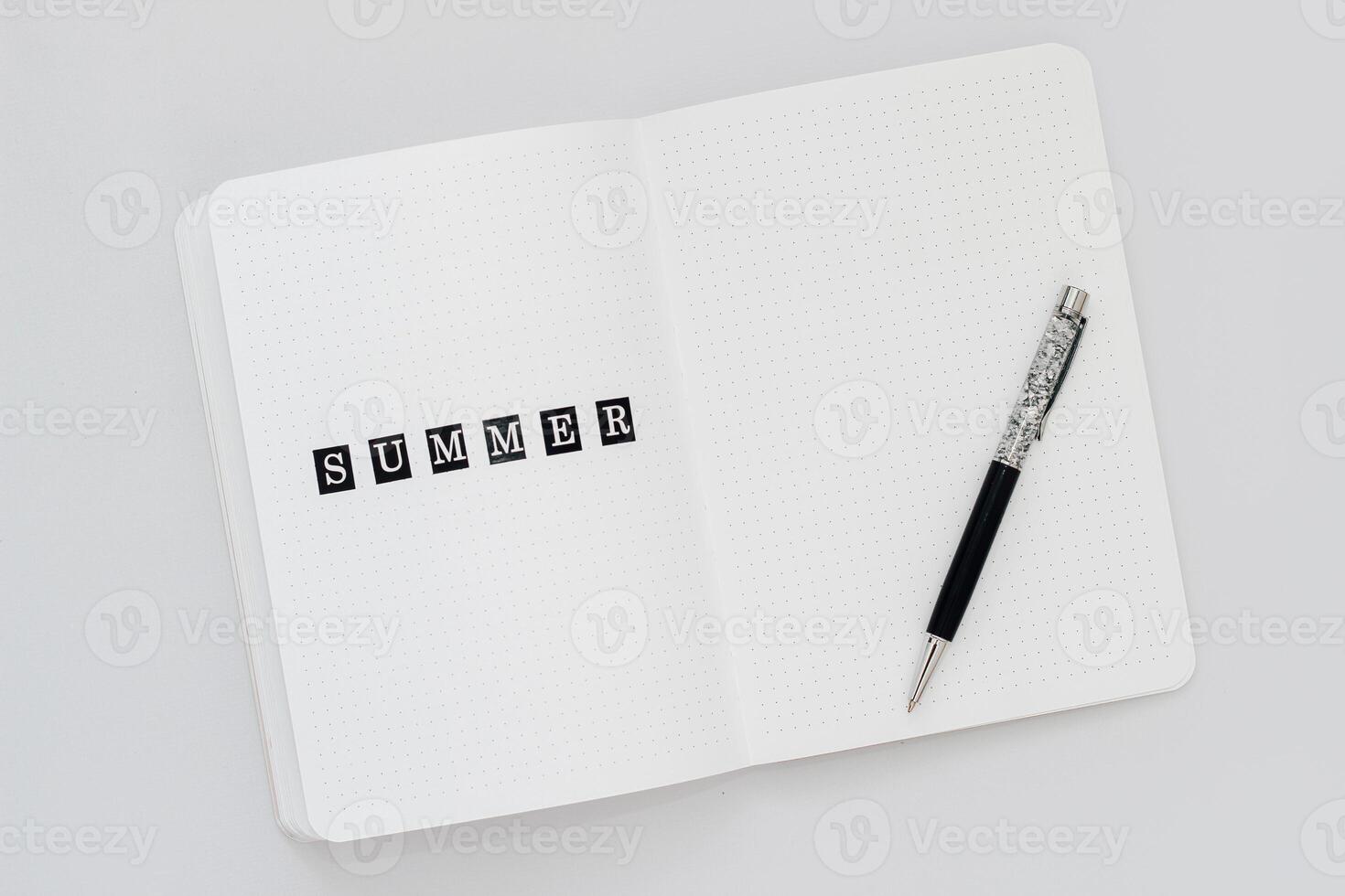 Filling in the diary, the inscription Summer in a notebook in a dot photo