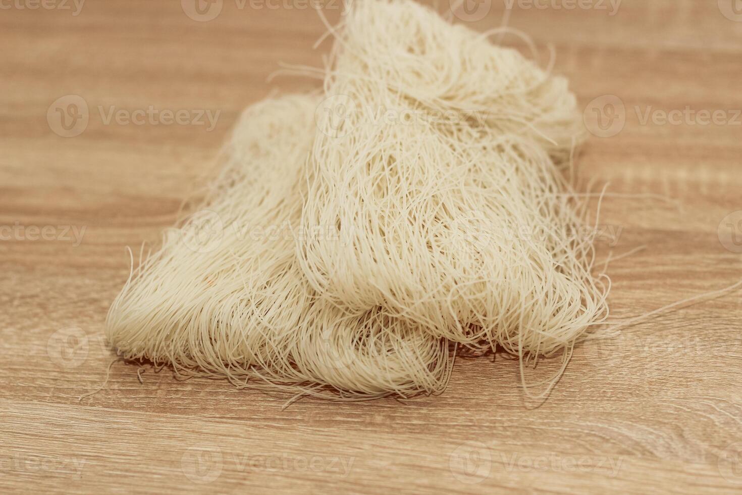 Funchoza rice glass noodles on a wooden board. photo