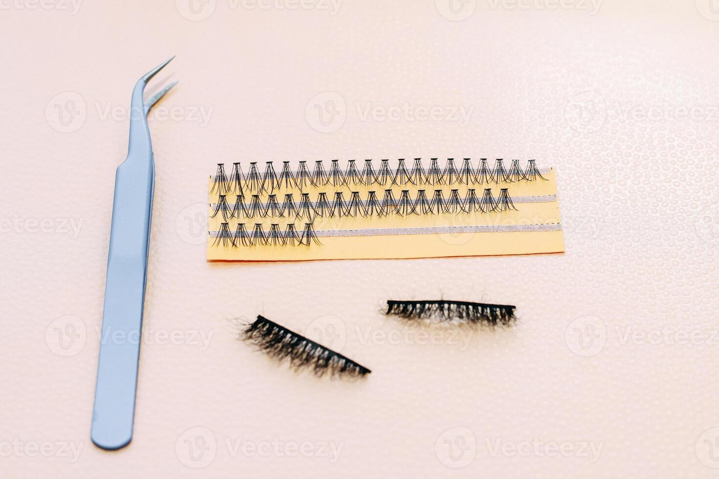 Artificial false fluffy eyelashes with tweezers. photo