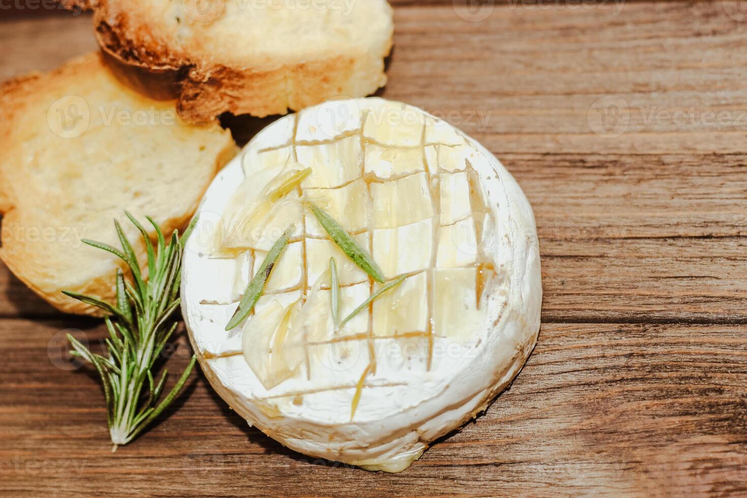 White baguette cut into pieces with olive oil and Camembert cheese on the table. photo